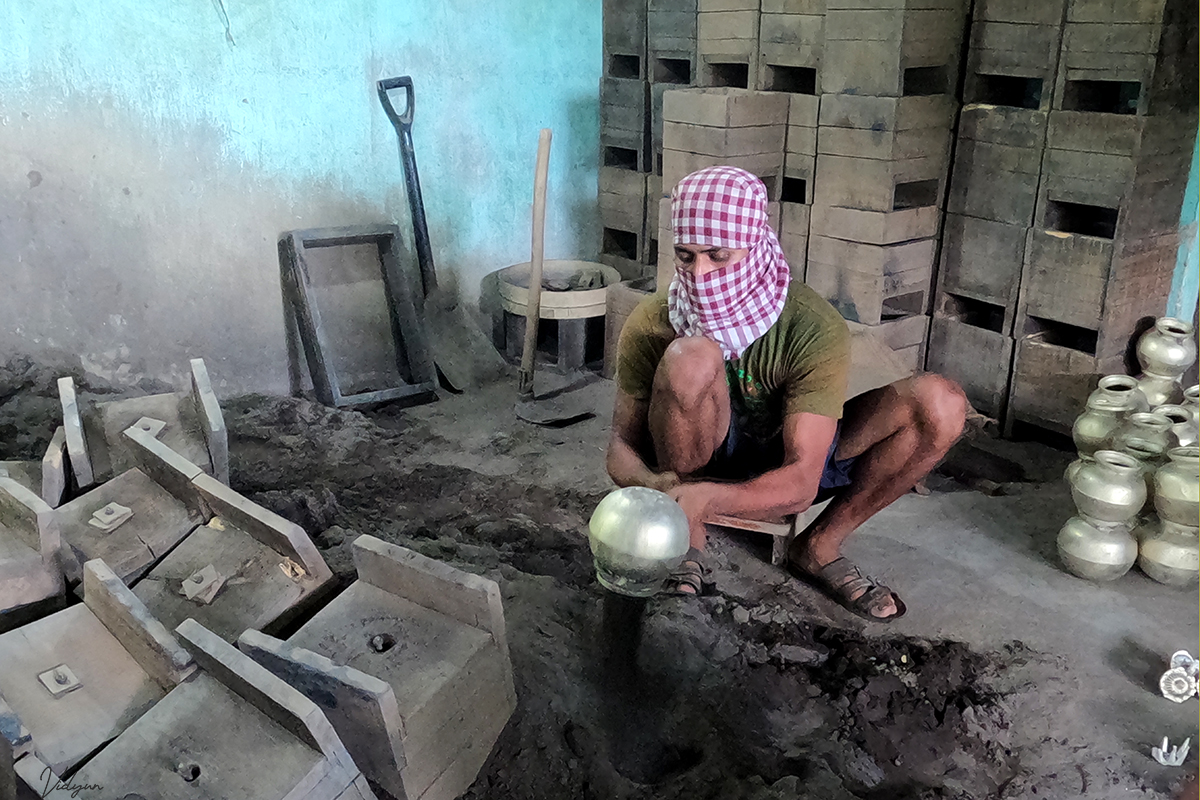 This is an image of a man making brass pots.