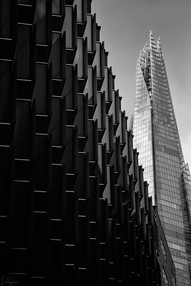 This is an image of the Shard building in London with another artistic building in the foreground