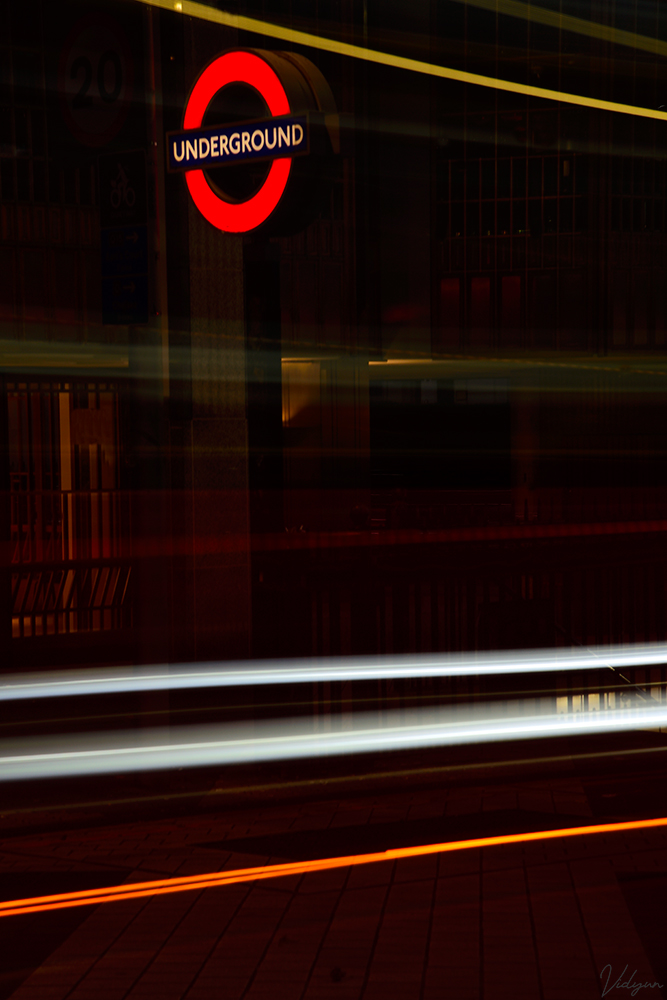 This is a long-exposure image image taken in London, with the iconic underground sign in the image